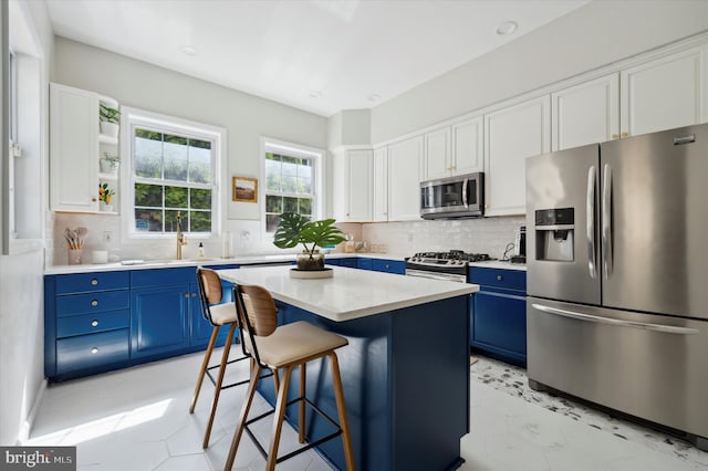 kitchen featuring white cabinetry, blue cabinets, a center island, and stainless steel appliances