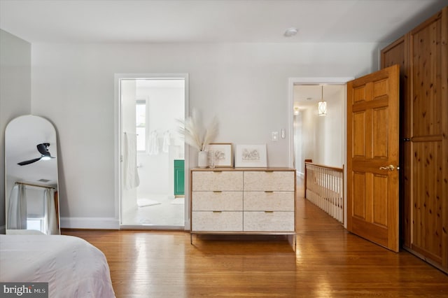 bedroom with connected bathroom and wood-type flooring