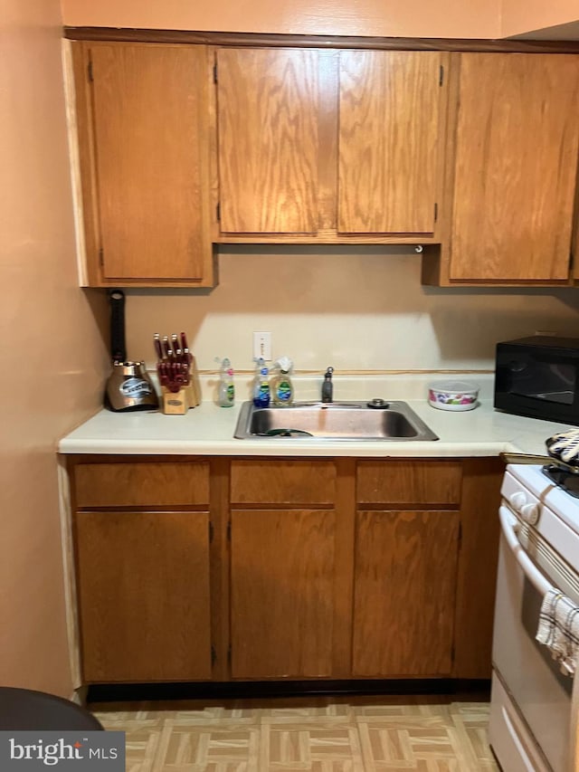 kitchen with sink and white range with gas stovetop