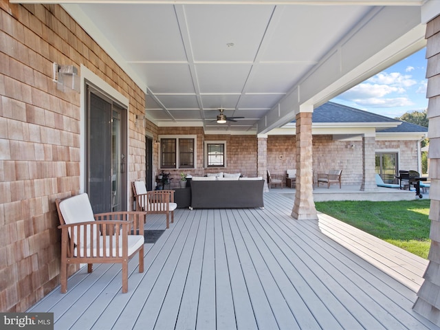 wooden deck featuring outdoor lounge area and ceiling fan