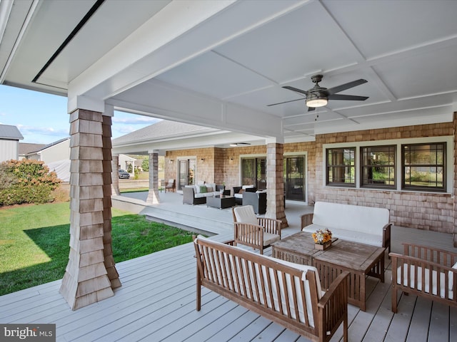 deck featuring a yard, an outdoor living space, and ceiling fan