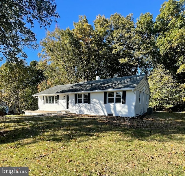 view of front of home with central AC and a front yard