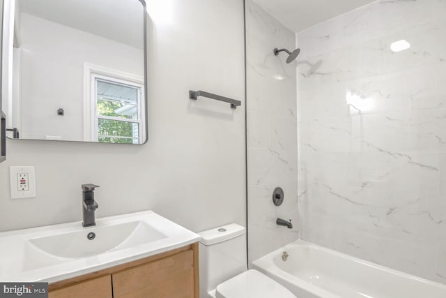 full bathroom with tiled shower / bath, vanity, and toilet