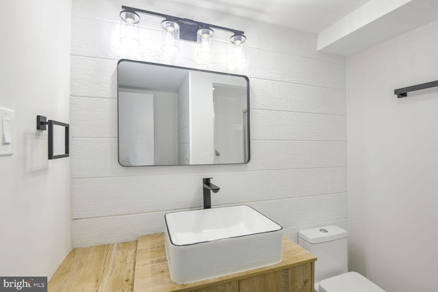 bathroom with wood-type flooring, vanity, and toilet