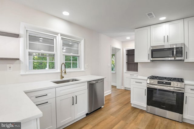 kitchen with sink, white cabinets, and appliances with stainless steel finishes