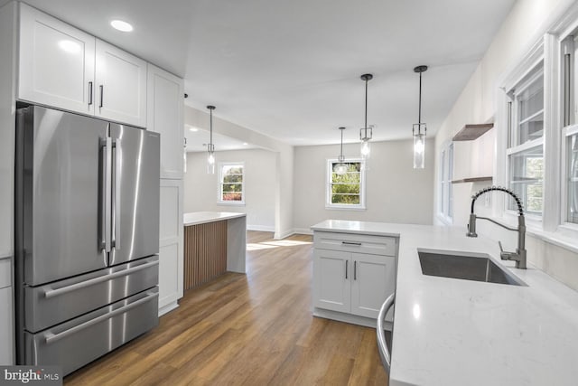 kitchen with white cabinets, dark hardwood / wood-style floors, high end fridge, and sink