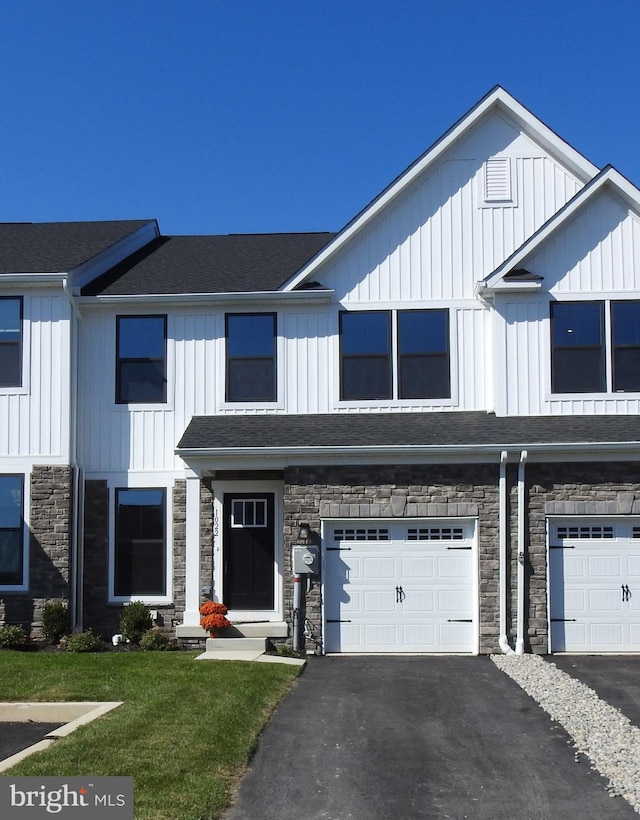 townhome / multi-family property with a front lawn and a garage