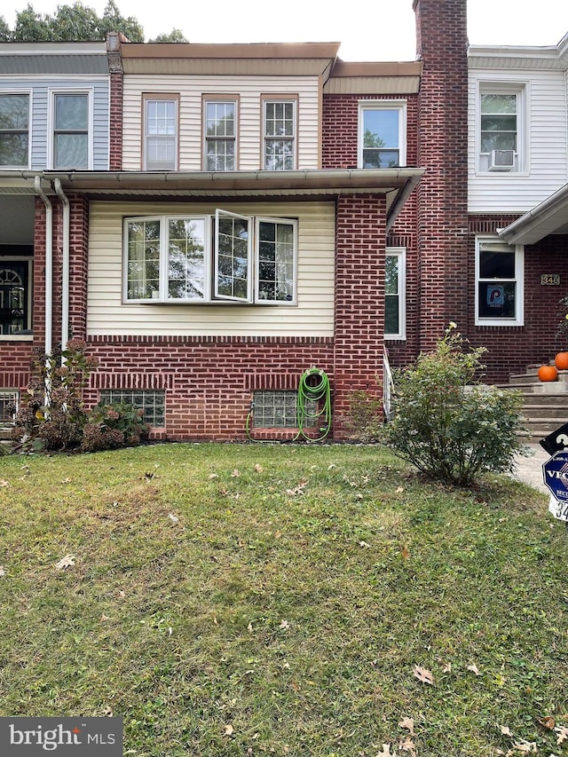 townhome / multi-family property featuring cooling unit and a front yard