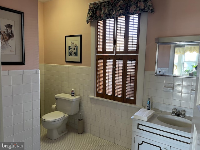 bathroom featuring tile patterned floors, vanity, tile walls, and toilet