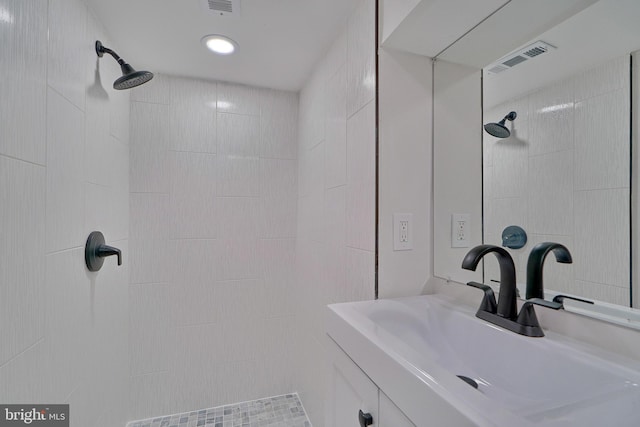 bathroom featuring a tile shower and vanity