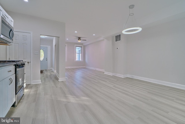 unfurnished living room featuring light hardwood / wood-style flooring and ceiling fan