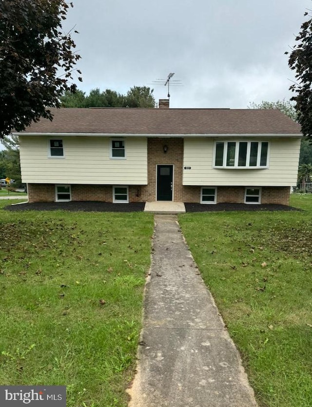 raised ranch featuring a front lawn