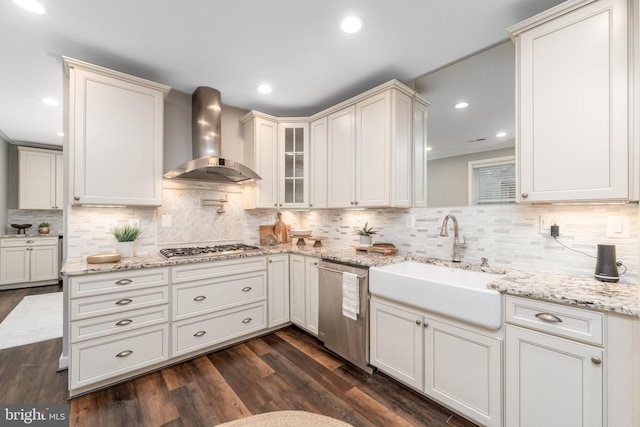 kitchen featuring stainless steel appliances, sink, dark hardwood / wood-style flooring, wall chimney range hood, and backsplash