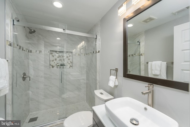 bathroom featuring an enclosed shower, toilet, and vanity