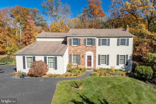 colonial home with a front lawn