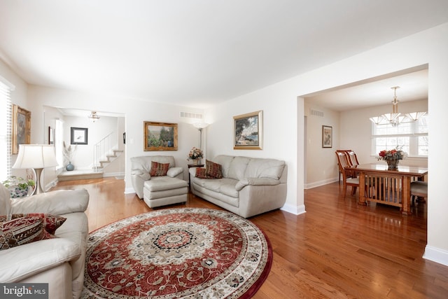 living room featuring wood-type flooring and a notable chandelier