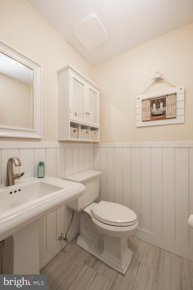 bathroom featuring wood-type flooring and toilet