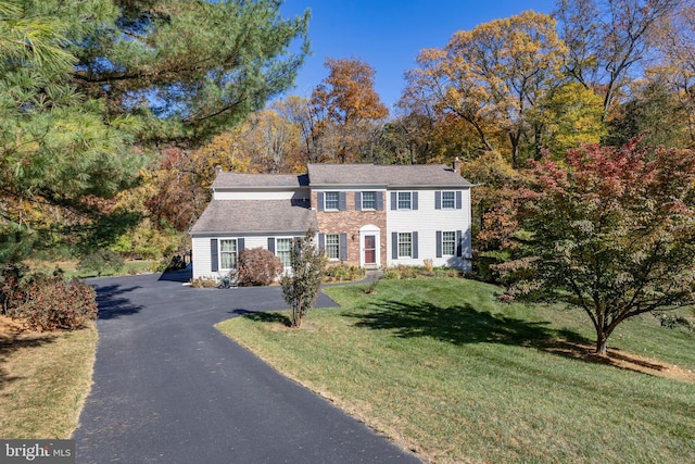 colonial-style house featuring a front yard