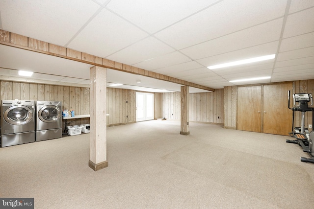 basement with washer and dryer, light colored carpet, a drop ceiling, and wooden walls