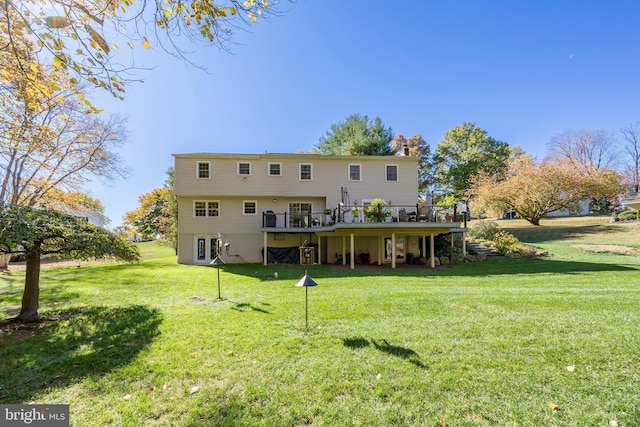 back of house featuring a lawn and a wooden deck