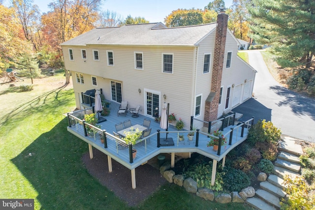 rear view of house featuring a yard and a wooden deck