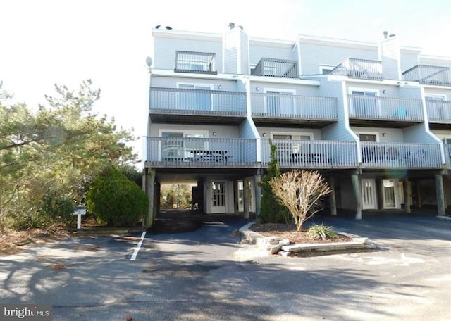 view of property with aphalt driveway and a carport