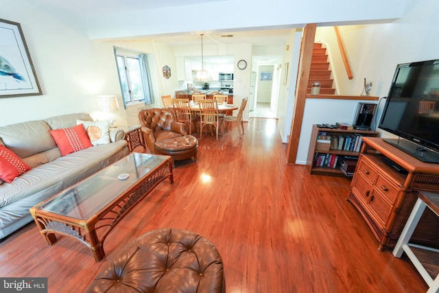 living room with wood finished floors and stairs