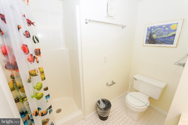 full bath with toilet, baseboards, and a stall shower