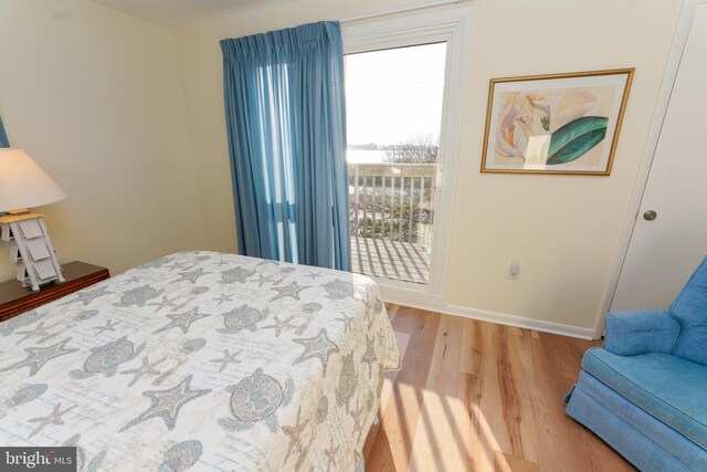 bedroom featuring baseboards, access to outside, and wood finished floors