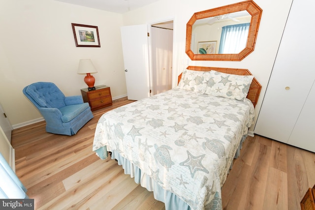 bedroom featuring wood finished floors, baseboards, and a closet