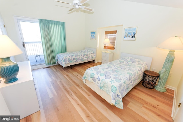 bedroom featuring ceiling fan, access to outside, wood finished floors, and lofted ceiling