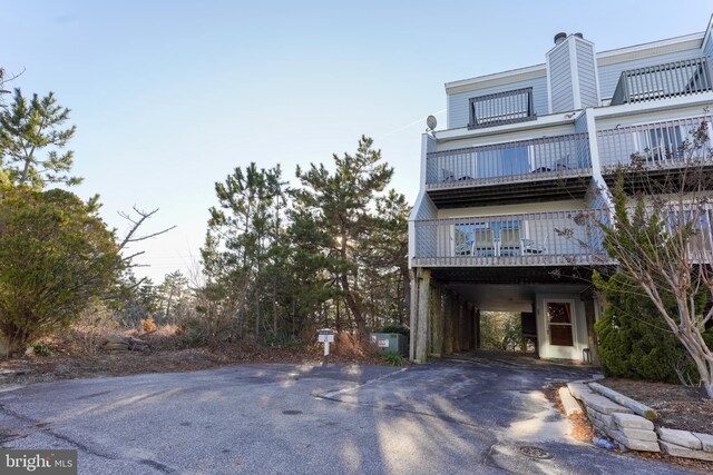 view of building exterior with aphalt driveway and a carport