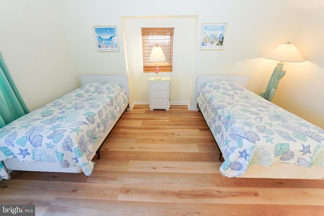 bedroom with baseboards and wood finished floors