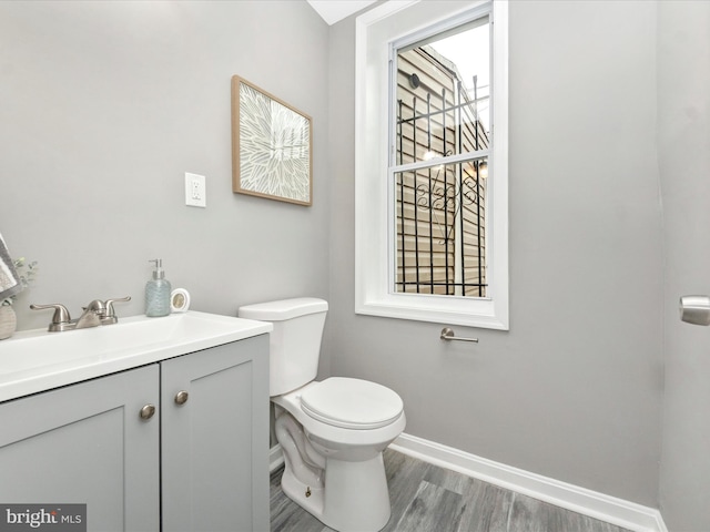 bathroom featuring wood-type flooring, vanity, and toilet