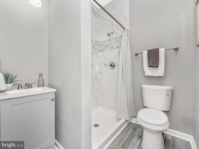 bathroom with wood-type flooring, toilet, vanity, and a shower with curtain