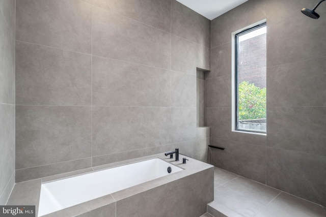 bathroom with tile patterned floors, tile walls, and shower with separate bathtub