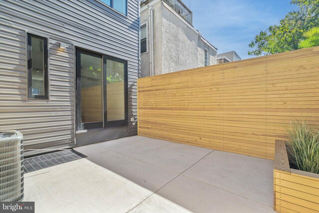 view of patio featuring cooling unit and fence