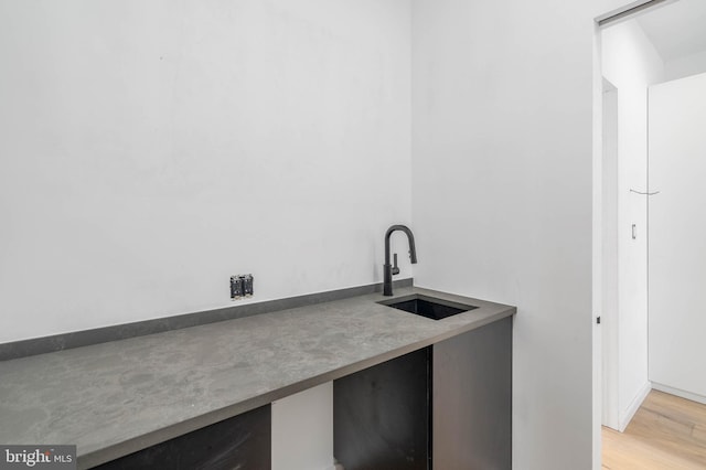 bar with hardwood / wood-style flooring and sink