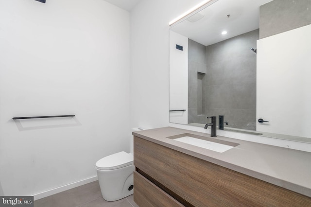 bathroom with a tile shower, tile patterned flooring, vanity, and toilet