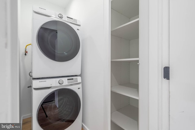 laundry area featuring hardwood / wood-style floors and stacked washer / dryer