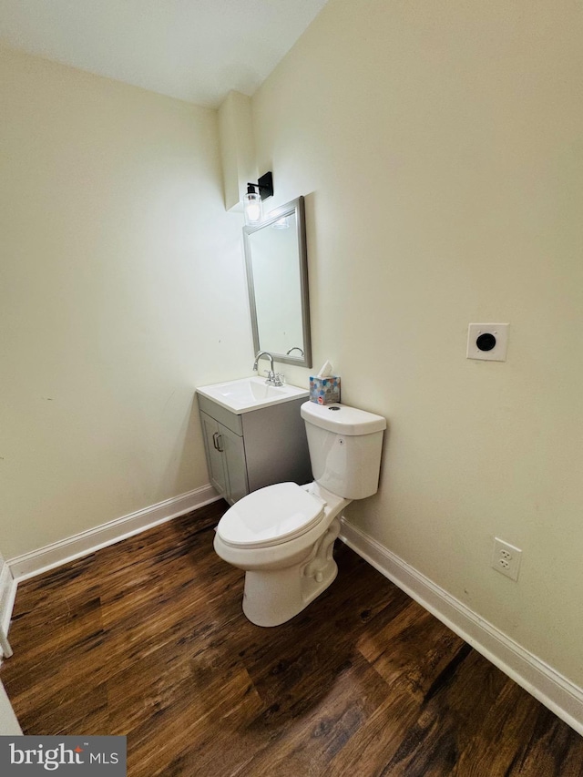 bathroom featuring vanity, hardwood / wood-style floors, and toilet