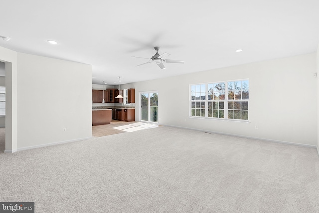 unfurnished living room with ceiling fan and light colored carpet