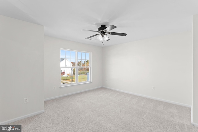 carpeted spare room featuring ceiling fan