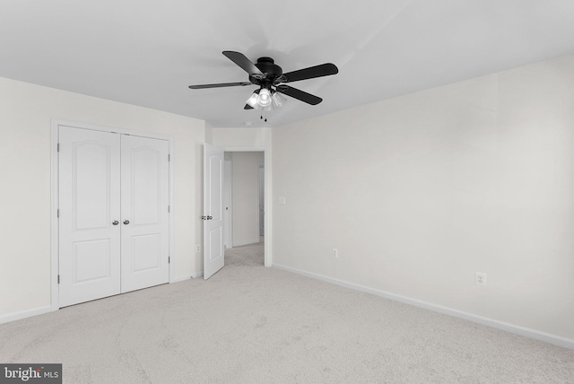 unfurnished bedroom with light carpet, a closet, and ceiling fan