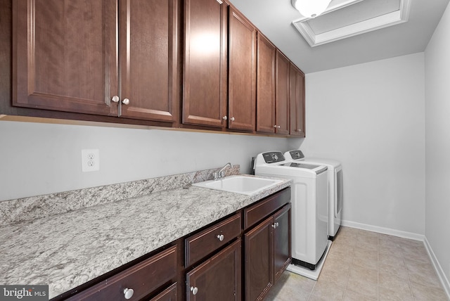 washroom featuring sink, washer and clothes dryer, and cabinets