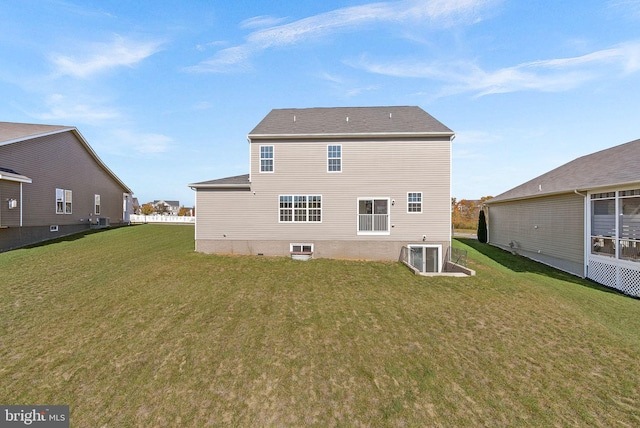 rear view of house featuring a yard and central AC