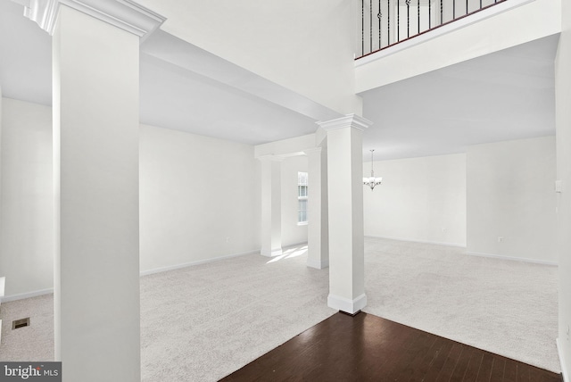 interior space with decorative columns, a chandelier, and dark hardwood / wood-style floors