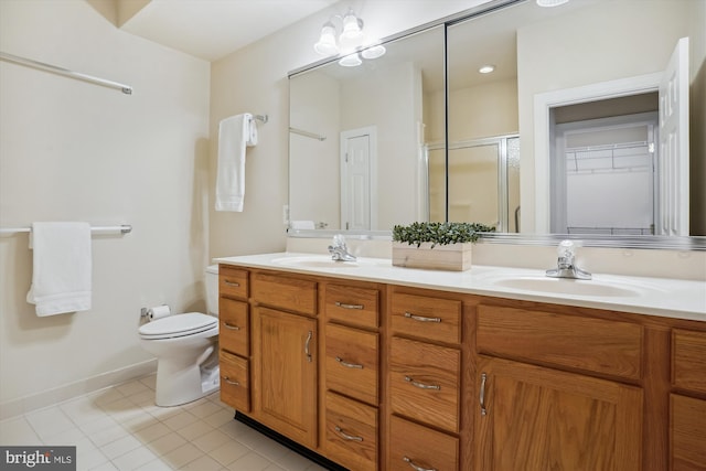 bathroom with tile patterned floors, vanity, a shower with shower door, and toilet