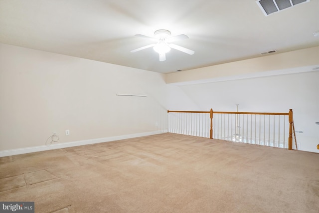 empty room with ceiling fan, light colored carpet, and vaulted ceiling