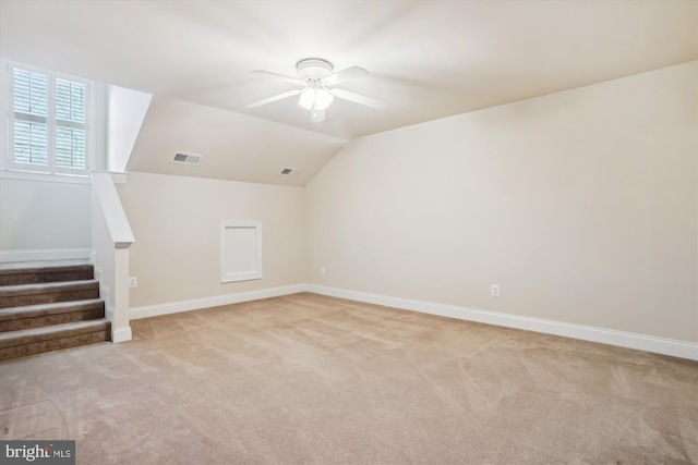 additional living space with light colored carpet, vaulted ceiling, and ceiling fan